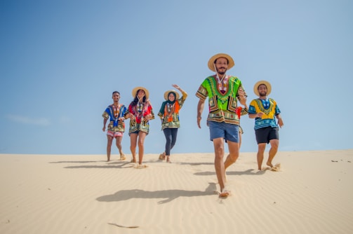 group of people running on brown sand during daytime