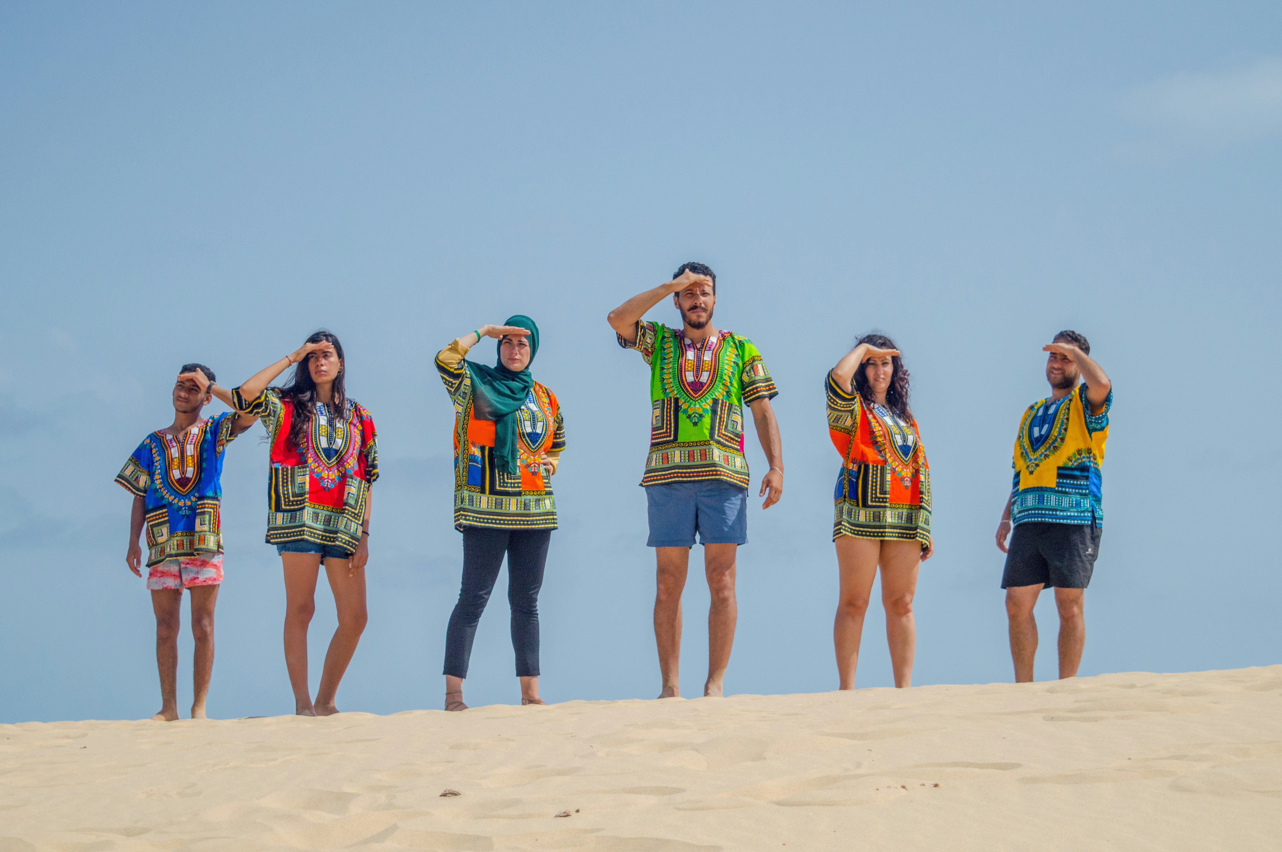 group of women standing on brown sand during daytime