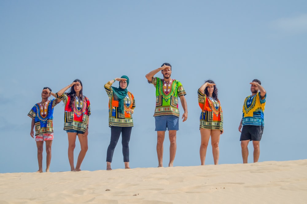 group of women standing on brown sand during daytime