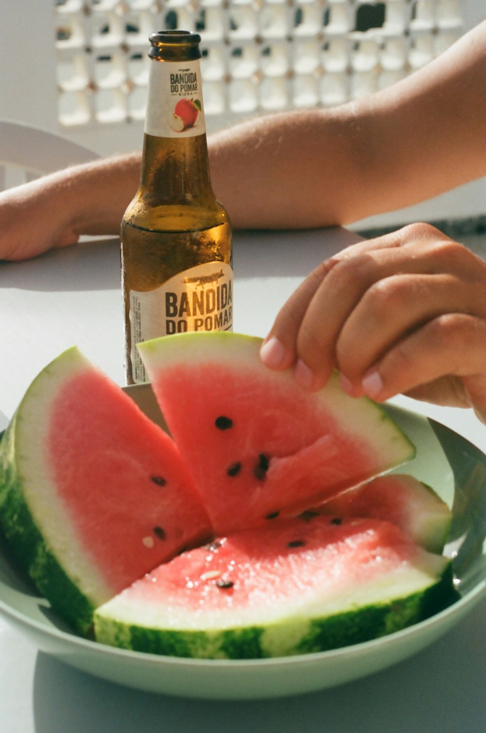 person holding brown glass bottle