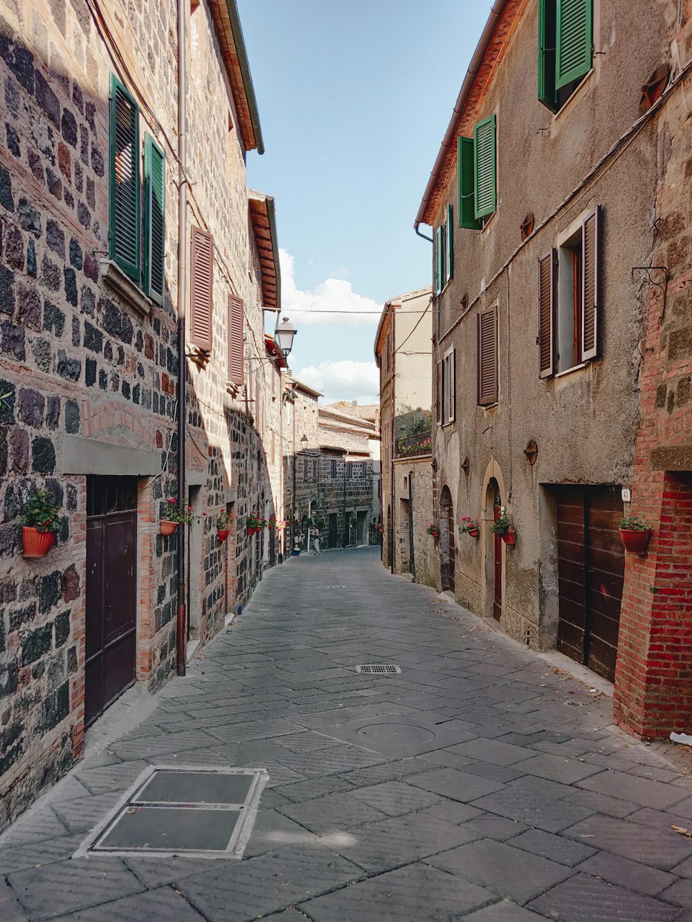 empty street between concrete houses during daytime