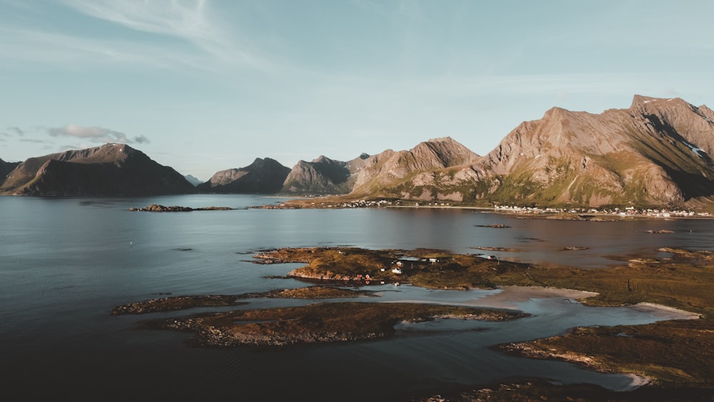 brown and white mountains beside body of water during daytime