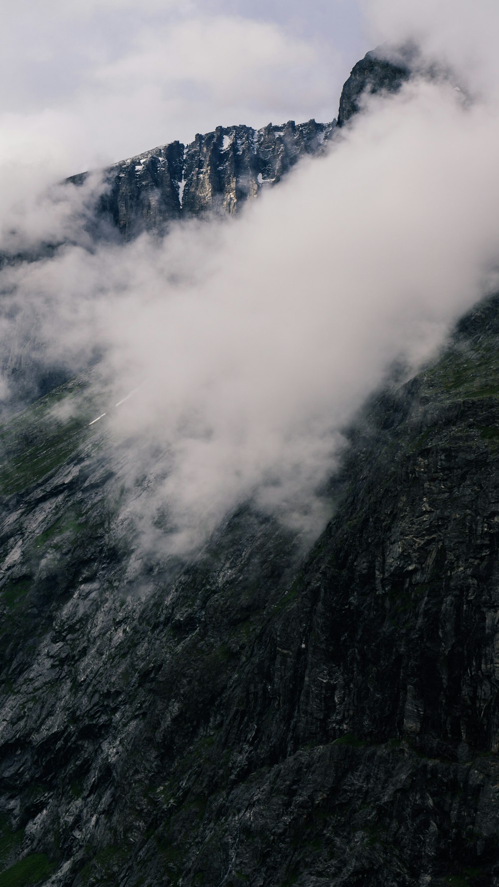 montaña gris y verde con nubes blancas