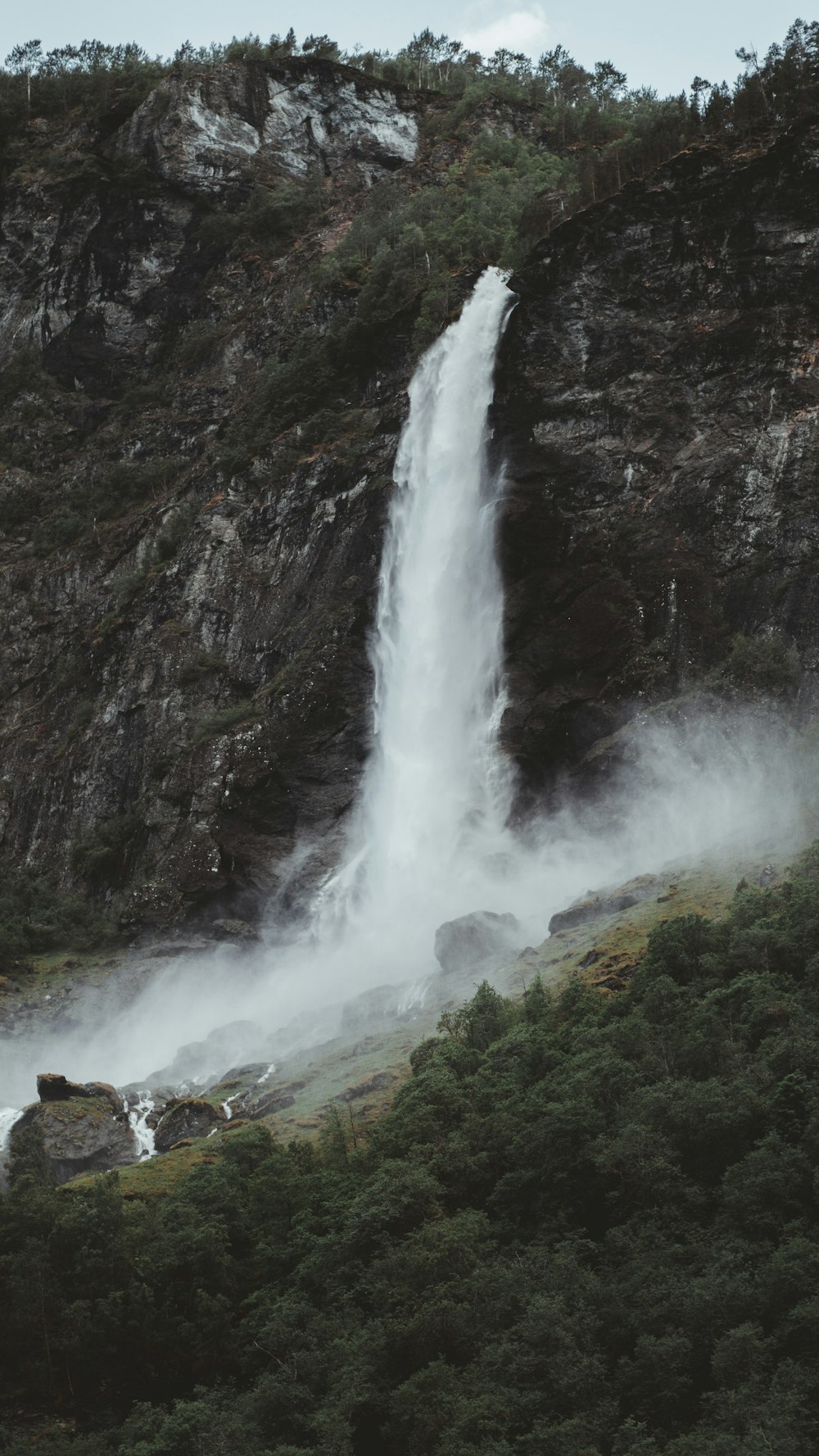 waterfalls on green grass field during daytime