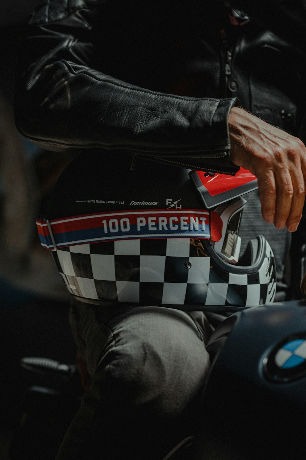 person in black leather jacket holding red and white ceramic mug