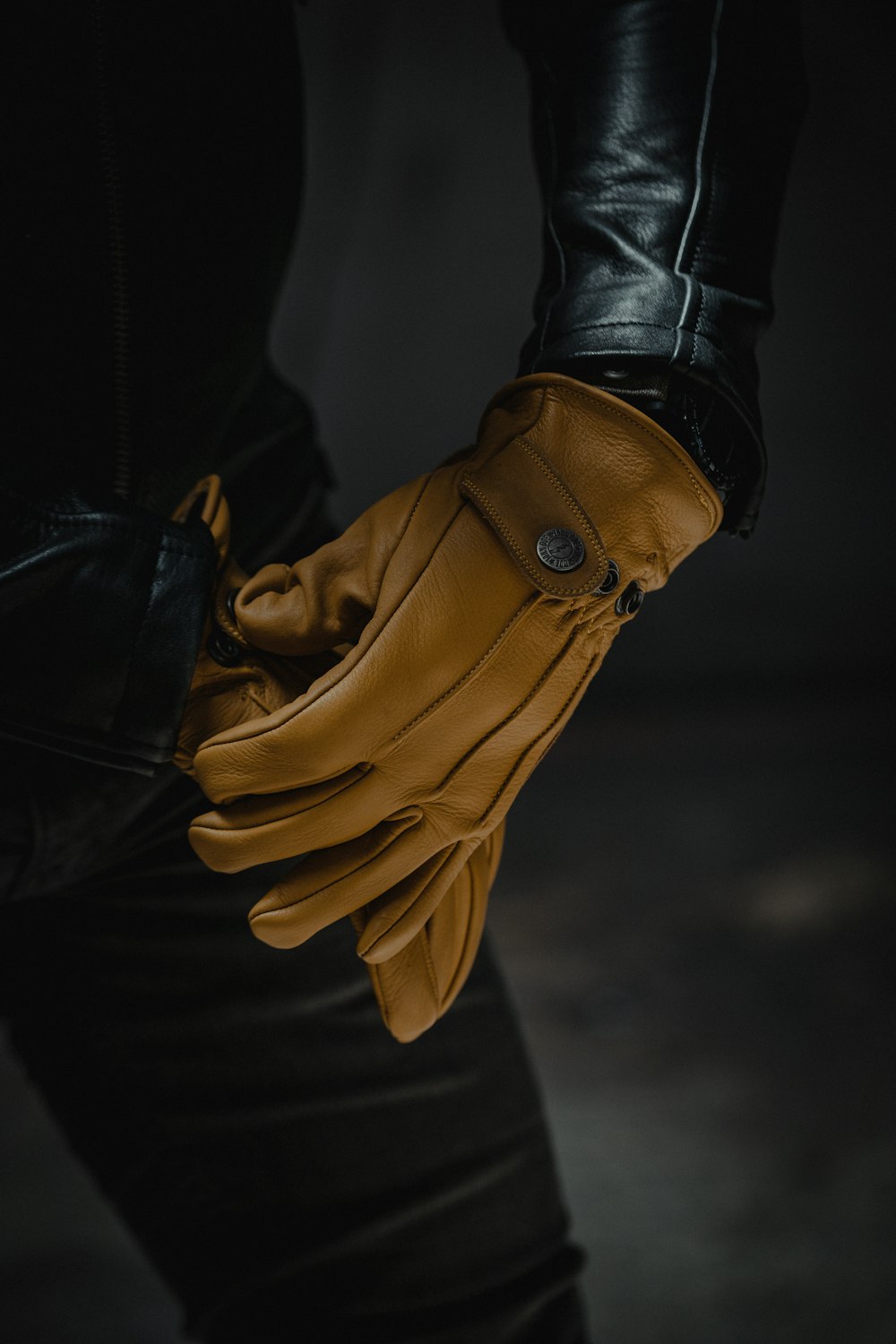 person wearing black leather gloves