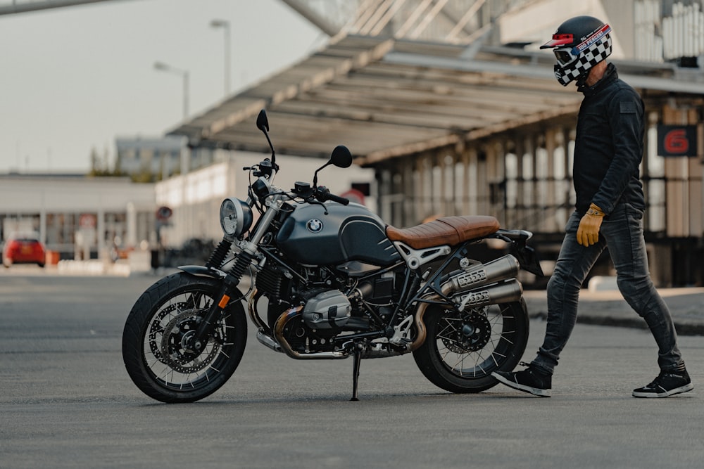 man in black leather jacket riding black motorcycle during daytime