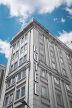 white concrete building under blue sky during daytime with HOTEL logo inscription