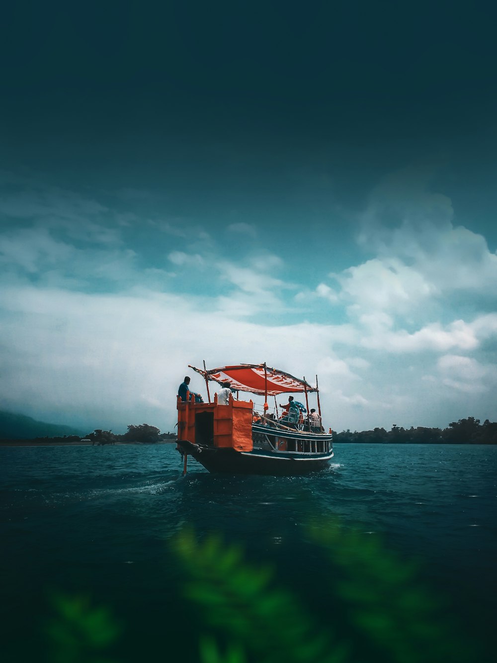 weißes und braunes Boot auf See unter blauem Himmel tagsüber