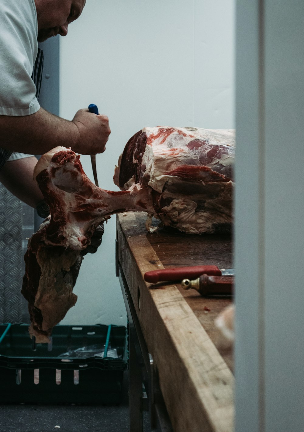 person holding raw meat on brown wooden table