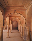 Clean hotel corridor adorned with saffron and gold accents reflecting temple architecture.