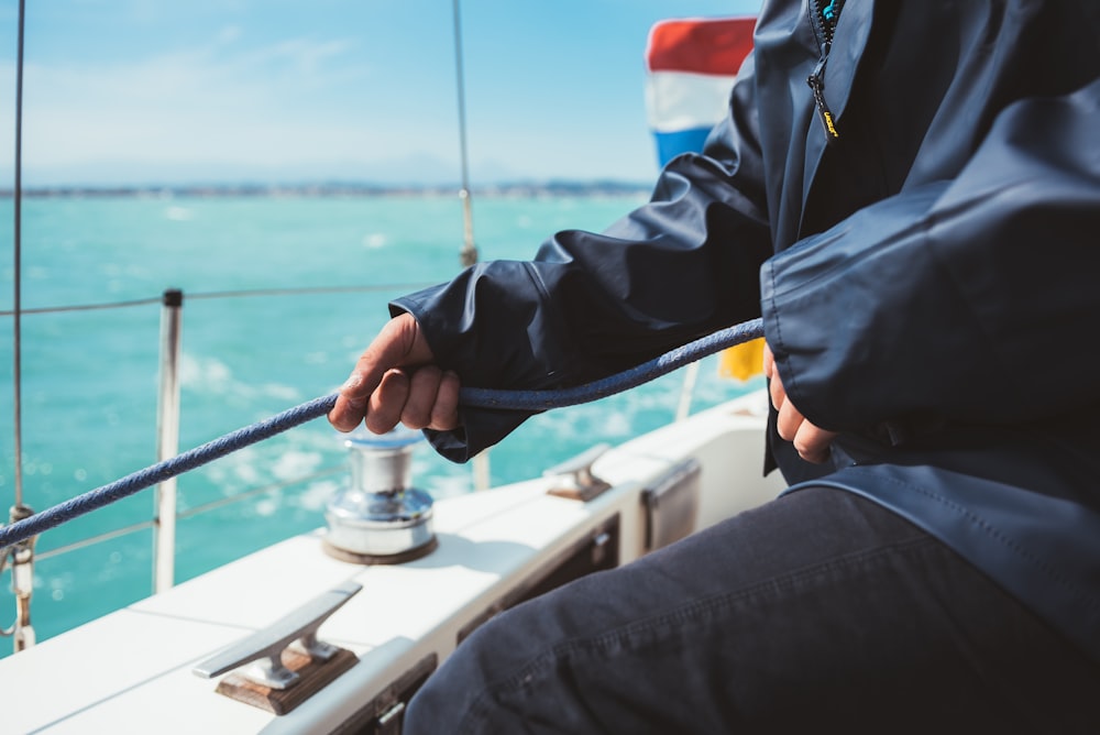 person in blue jacket holding black fishing rod