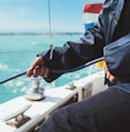 person in blue jacket holding black fishing rod