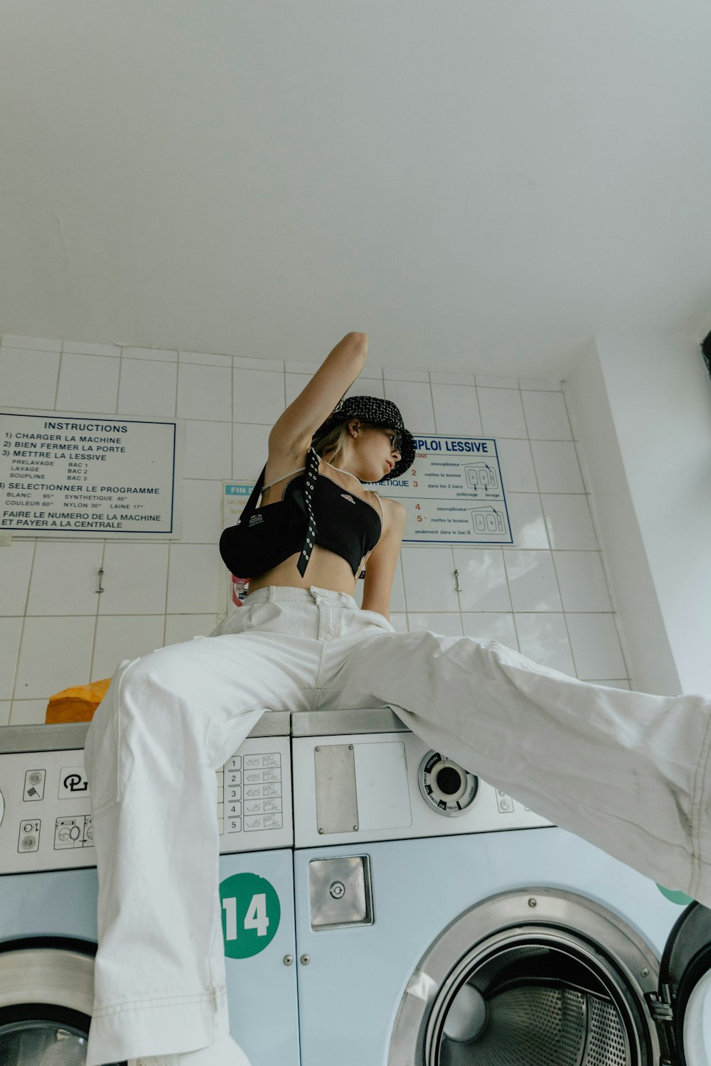 woman in black brassiere and white pants lying on bed