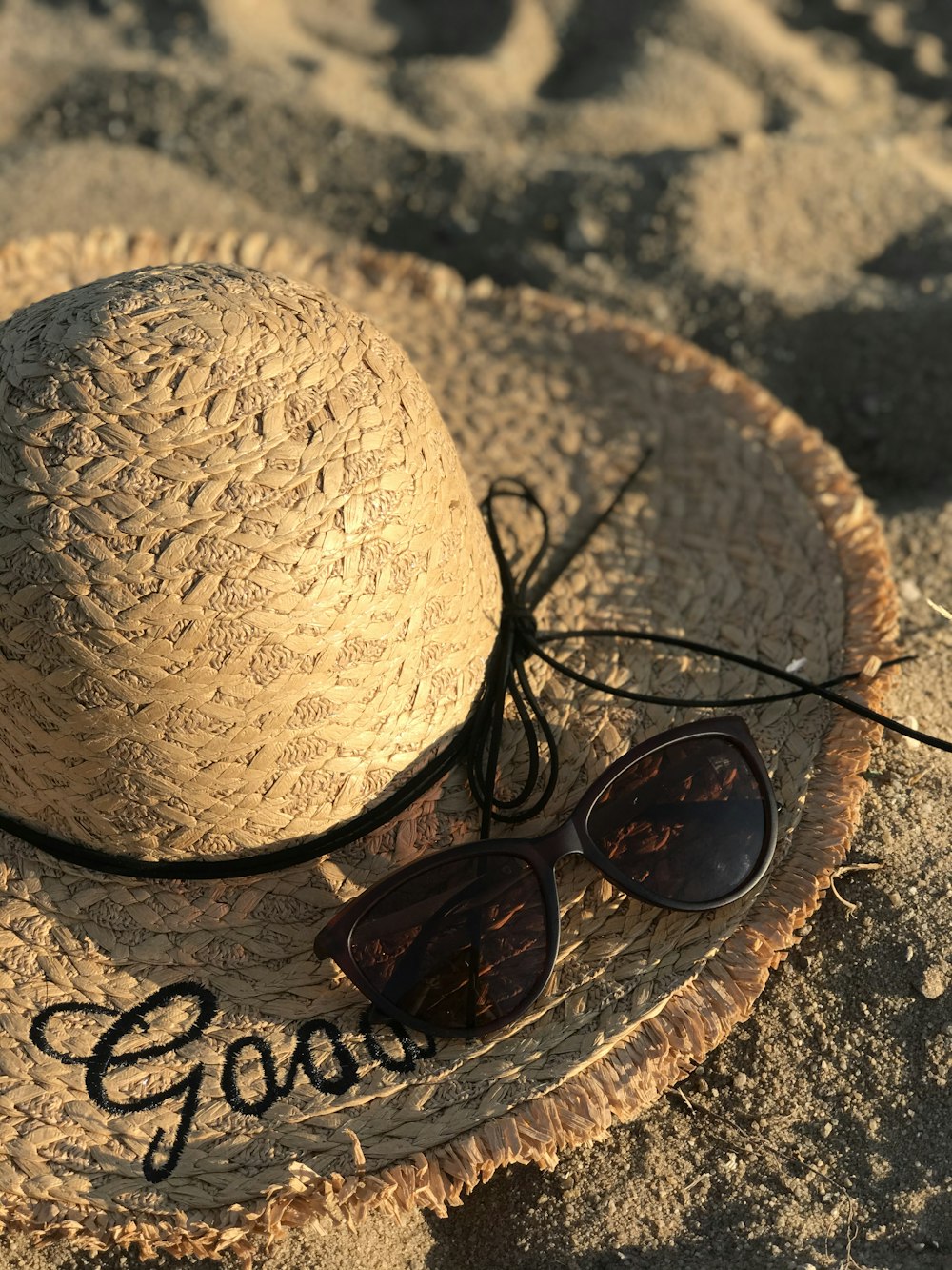 lunettes de soleil à monture noire sur chapeau de soleil marron