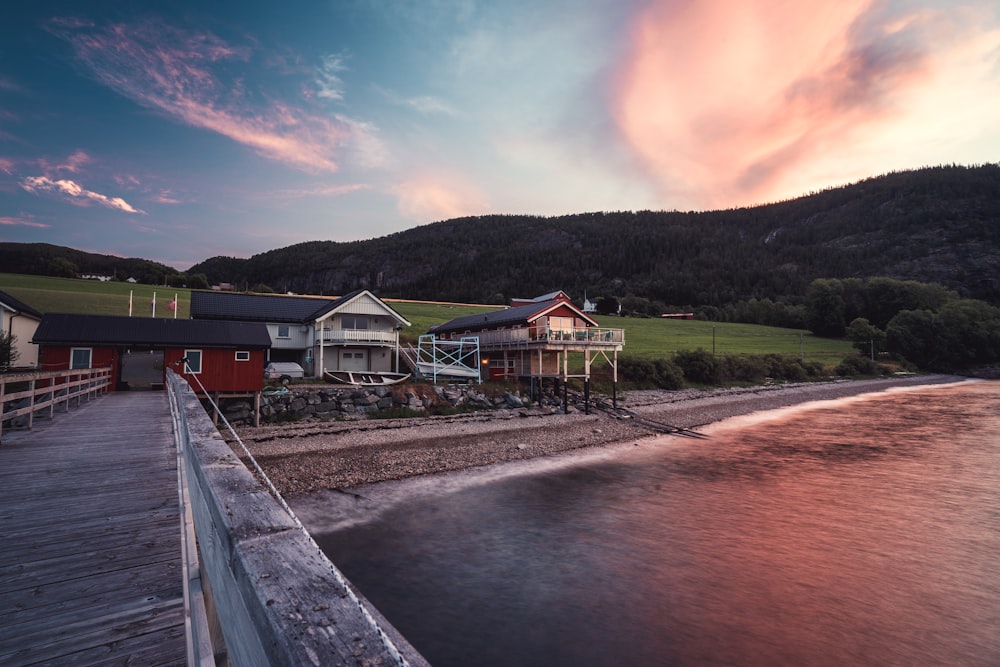 houses near river and mountain during daytime