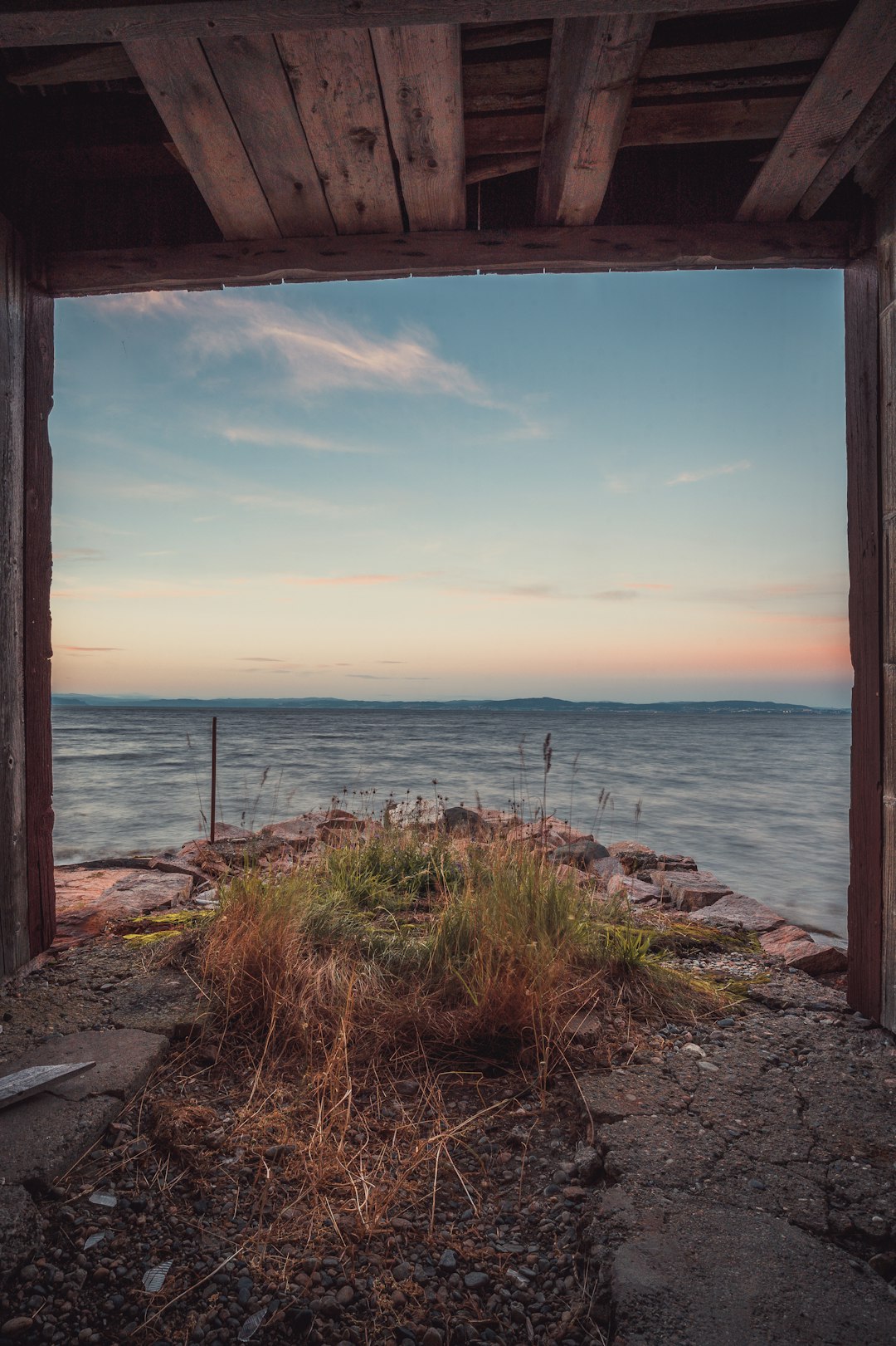 brown wooden fence near body of water during daytime