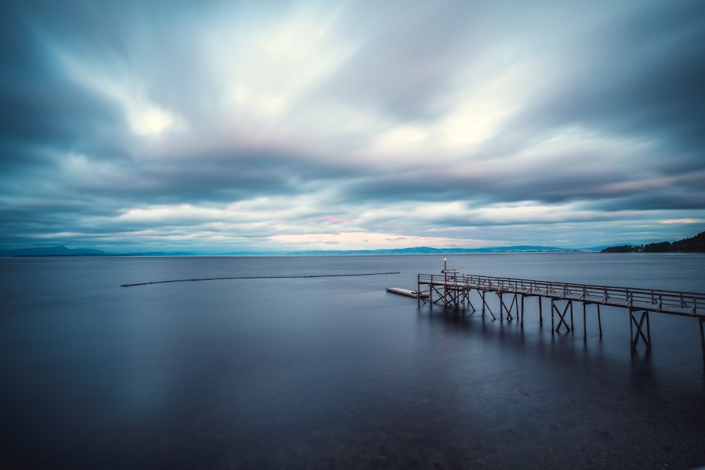 black metal railings on sea under blue sky during daytime