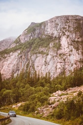 A scenic view of a car driving through a picturesque landscape.