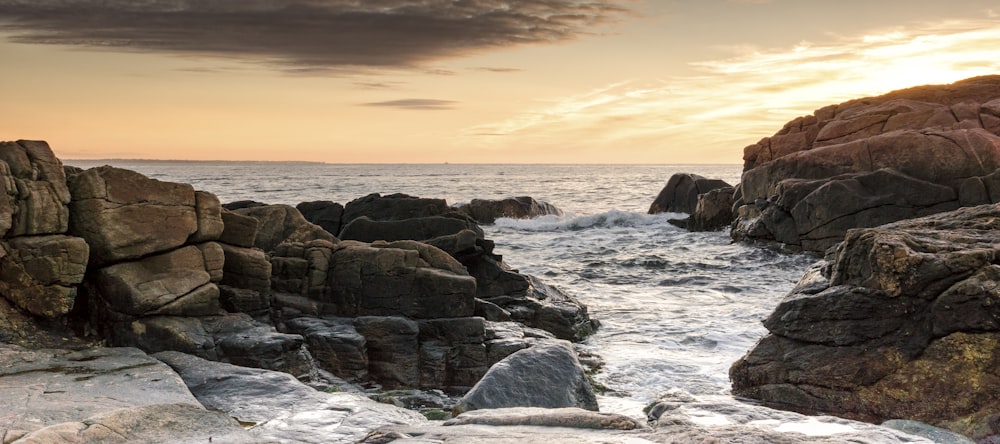 brown rocky shore during sunset