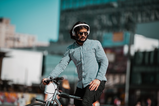 man in white and black striped dress shirt and black pants riding bicycle during daytime