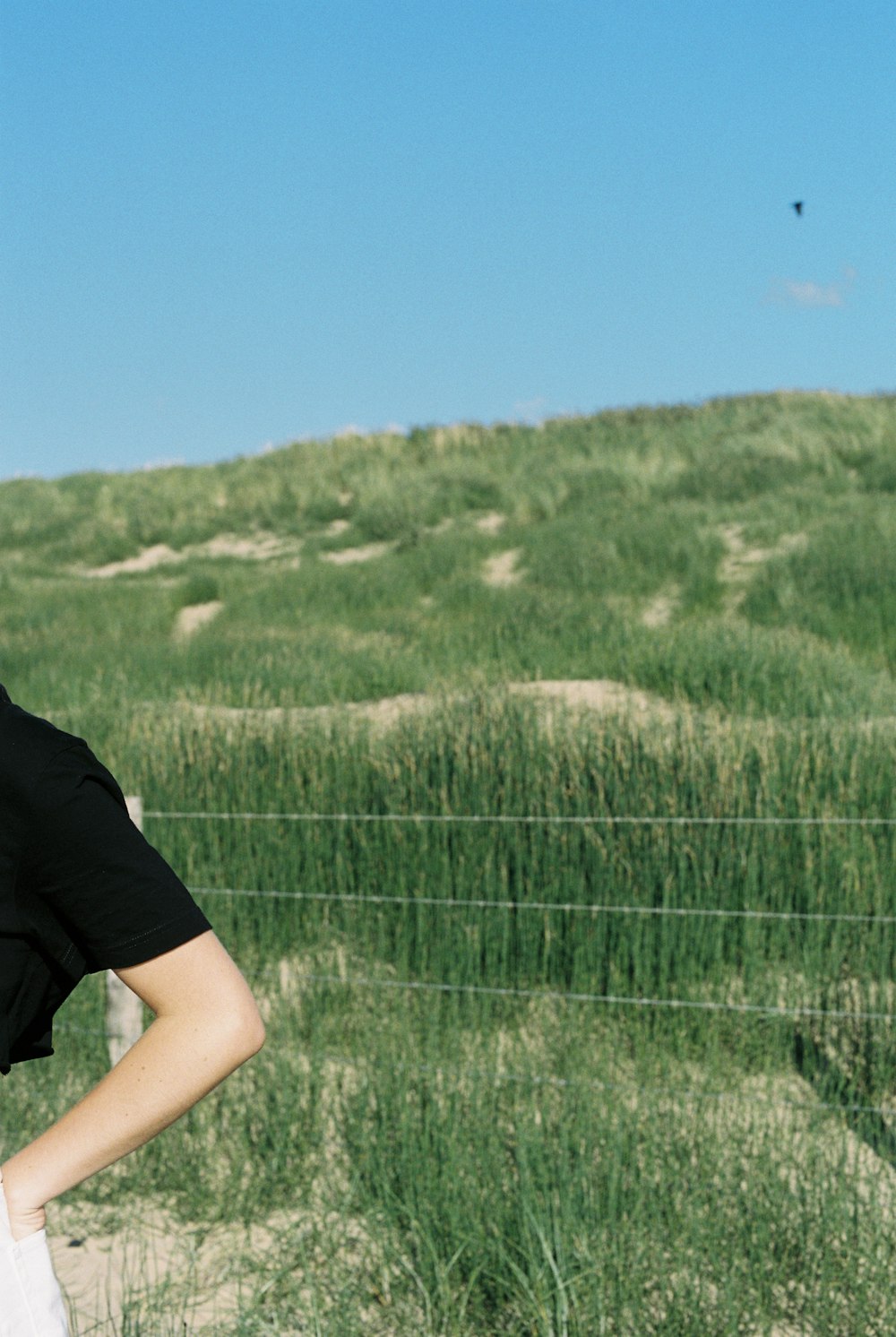 man in black t-shirt standing on green grass field during daytime