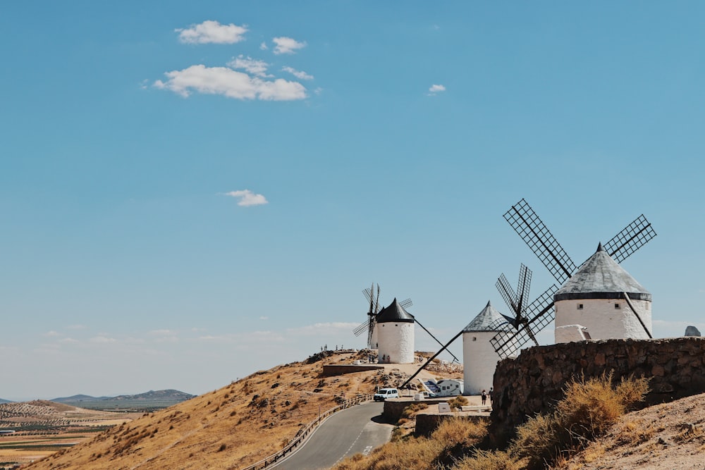 weiße Windmühle auf braunem Feld unter blauem Himmel tagsüber