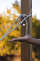 A pair of earbuds tangled gently on a denim jacket pocket outdoors.