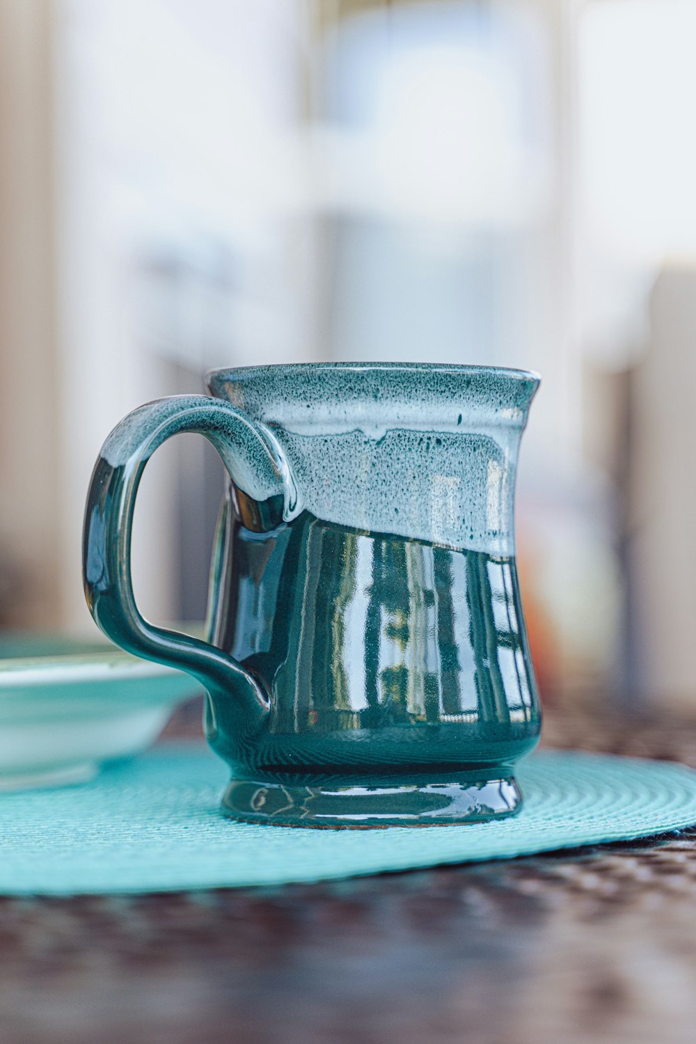blue ceramic mug on blue table cloth