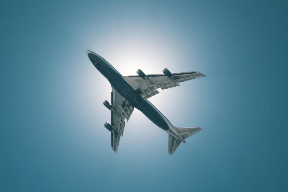 white and black airplane in mid air during daytime