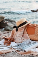 A lightweight bamboo beach tote resting on sandy shore with ocean waves in the background.