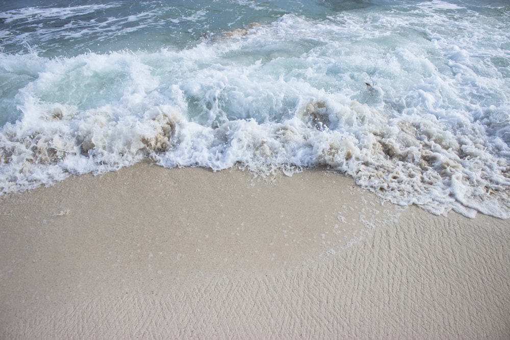 sea waves crashing on shore during daytime