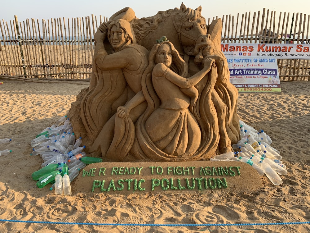 statua di cemento marrone sulla spiaggia durante il giorno