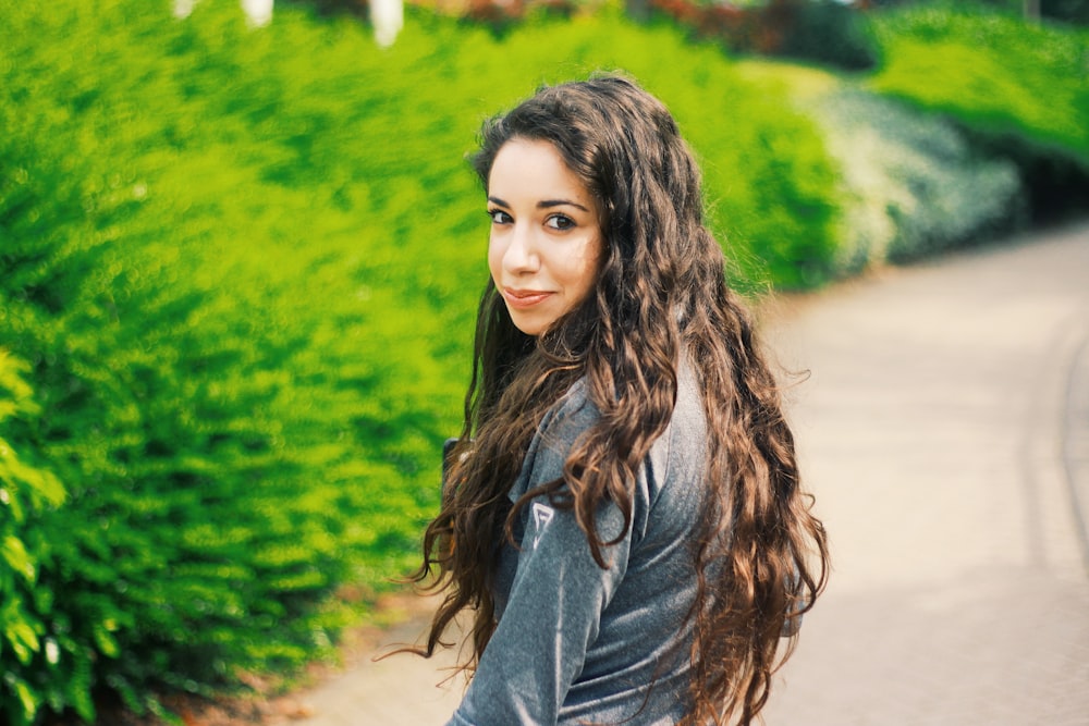 woman in black long sleeve shirt standing near green plants during daytime