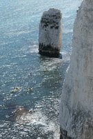 Tourists kayaking through crystal-clear lagoons surrounded by towering rock formations.