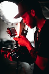 man in black and red long sleeve shirt holding black video camera