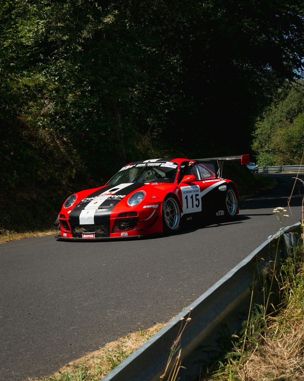 a red and white race car driving down a road