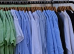 white blue and gray clothes hanging on brown wooden rack