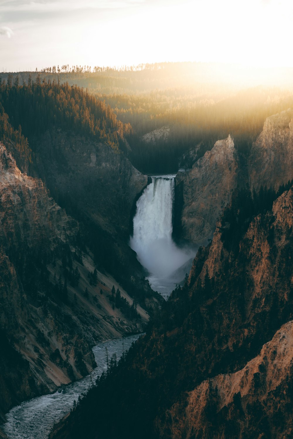 waterfalls in the middle of brown mountains during daytime