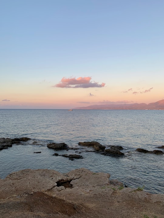 black rocks on sea shore during sunset in Crete Greece