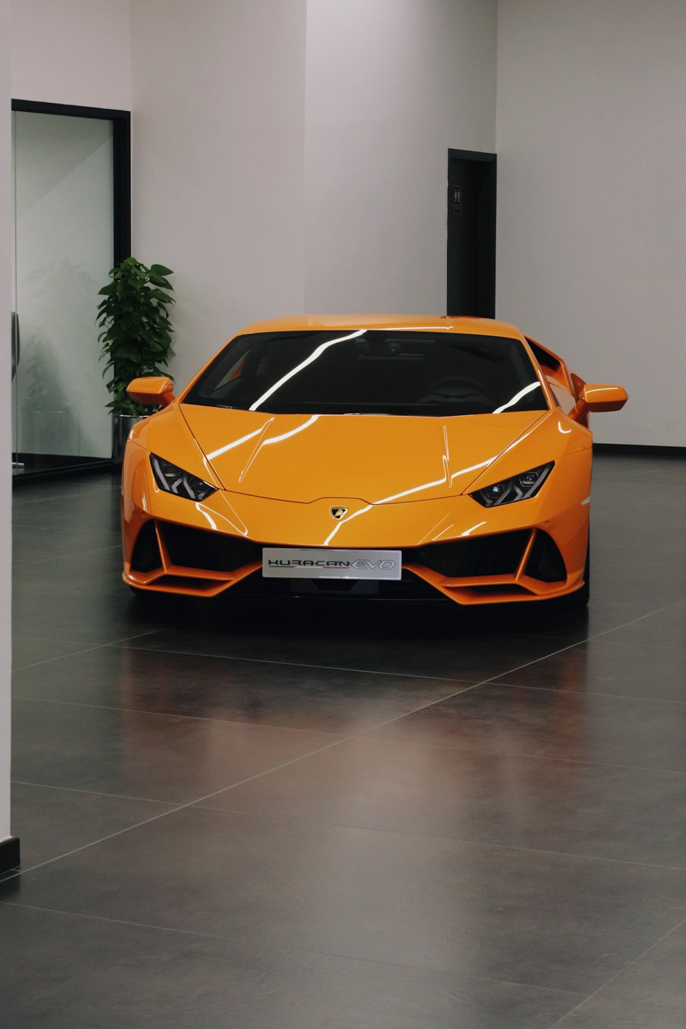 orange lamborghini aventador parked on gray floor