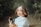 woman in white button up shirt holding black smartphone