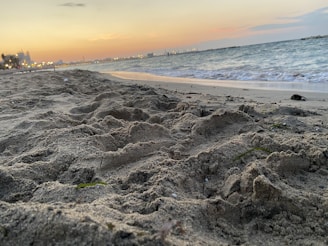 A cozy beachfront hotel at sunset with glowing lights and calm waves.
