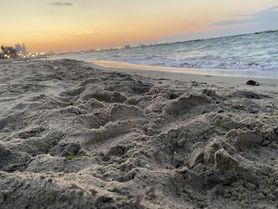 A cozy beachfront hotel at sunset with glowing lights and calm waves.