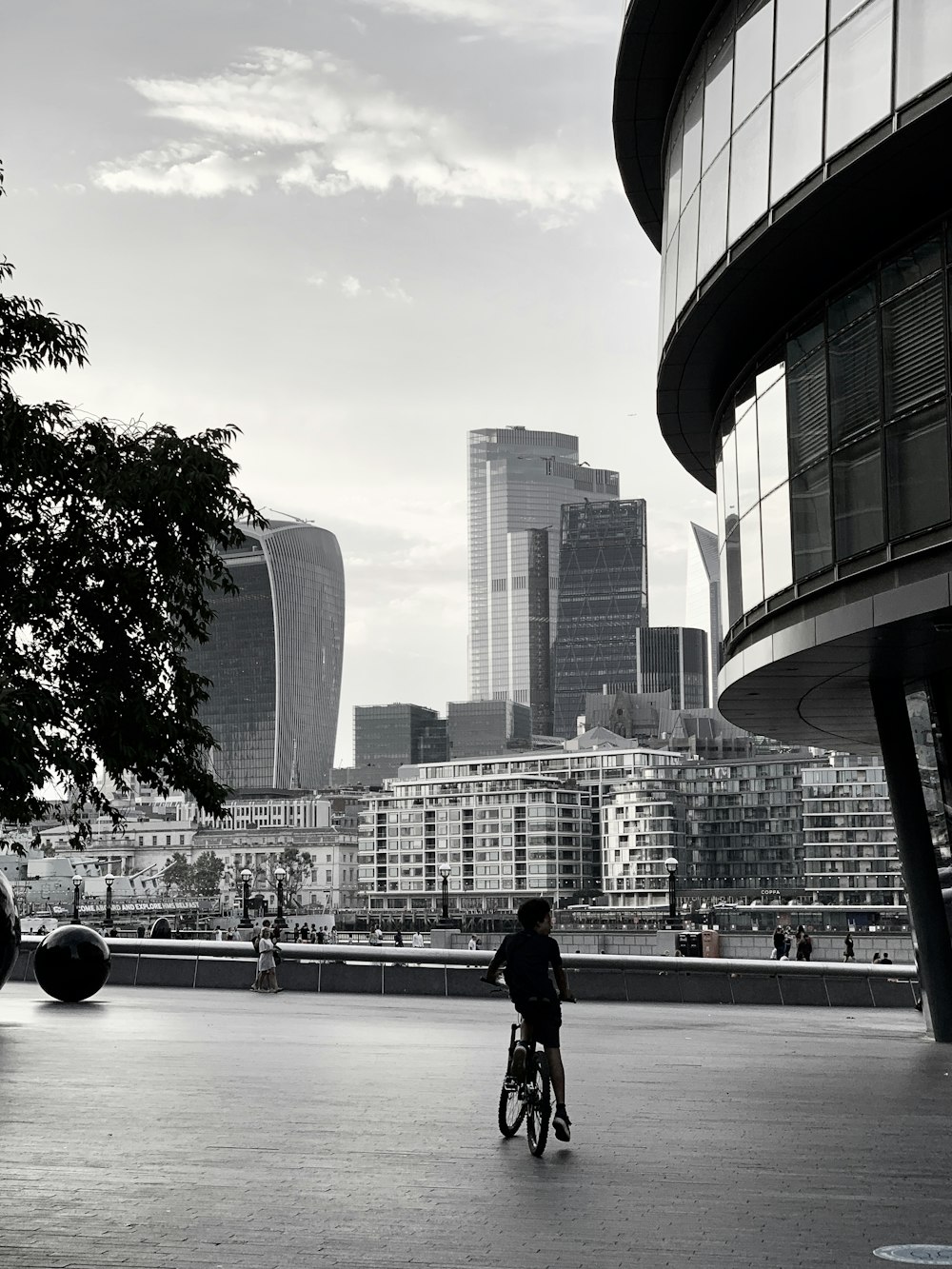 man in black jacket walking on sidewalk near city buildings during daytime