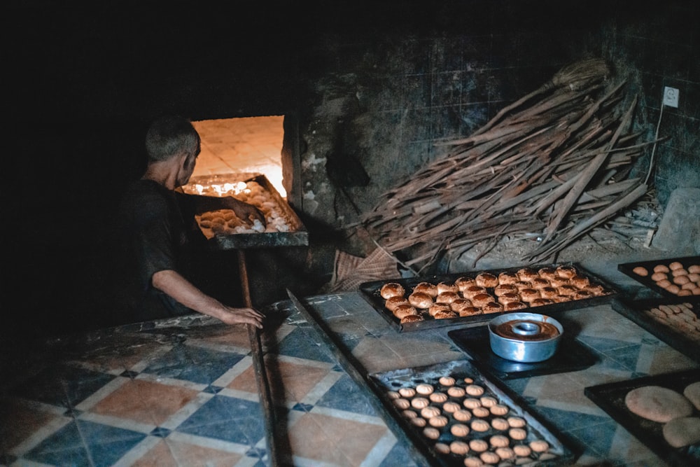 man in black shirt cooking on grill