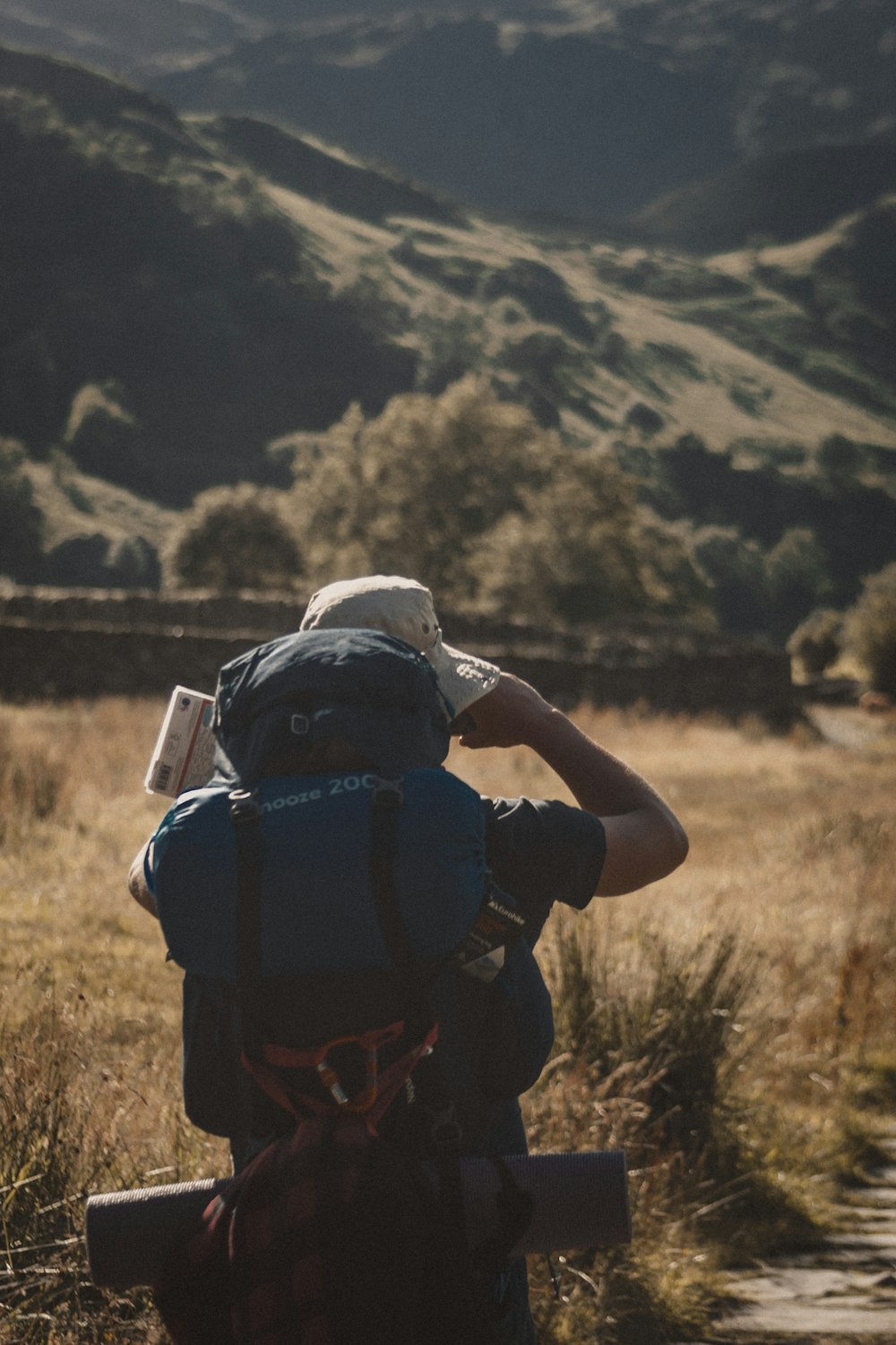 man in black t-shirt and black backpack standing on brown grass field during daytime