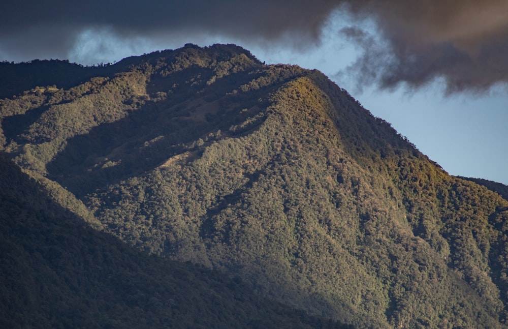 green and brown mountain under cloudy sky during daytime