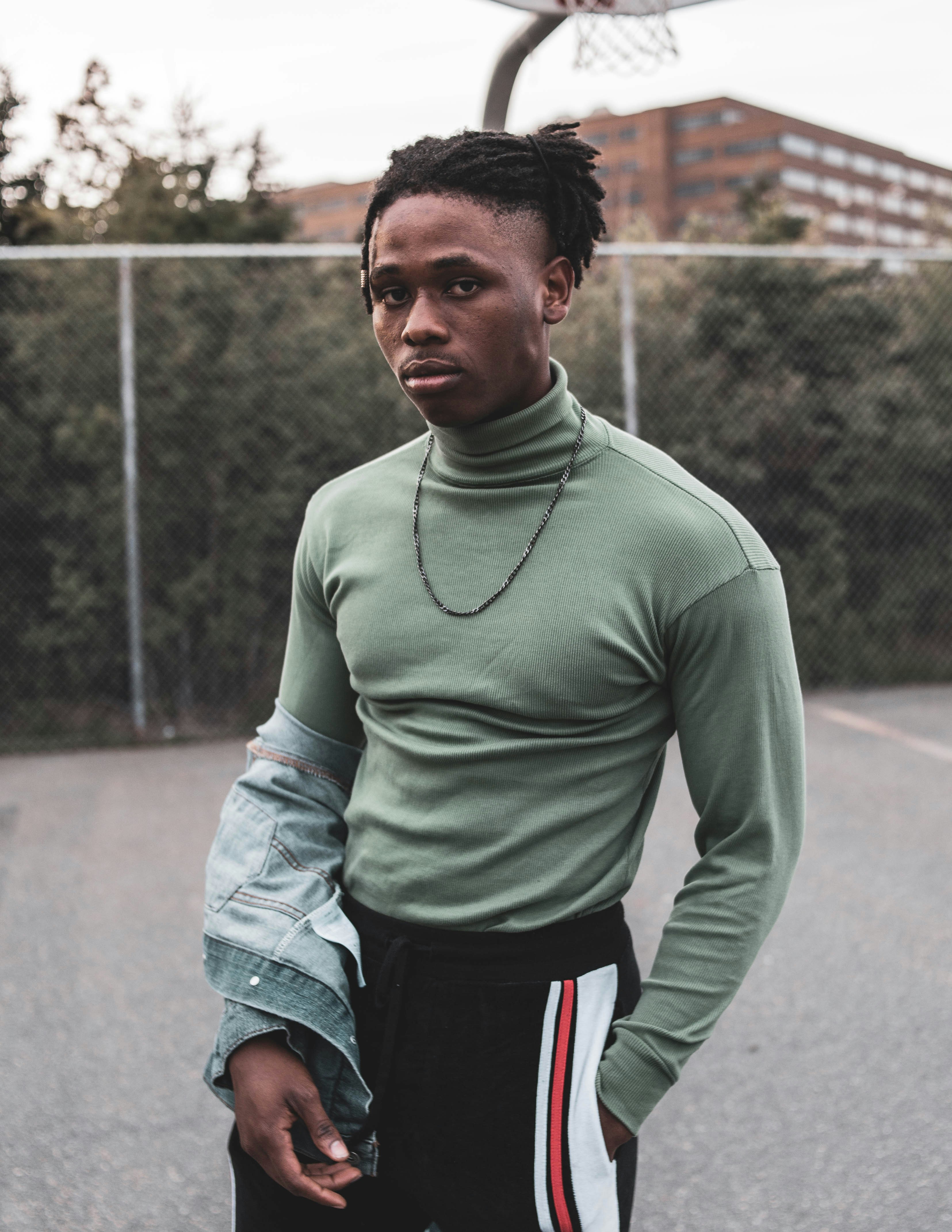 Foto hombre con verde y pantalones cortos negros y rojos parados en durante el día – Imagen Gris gratis en Unsplash