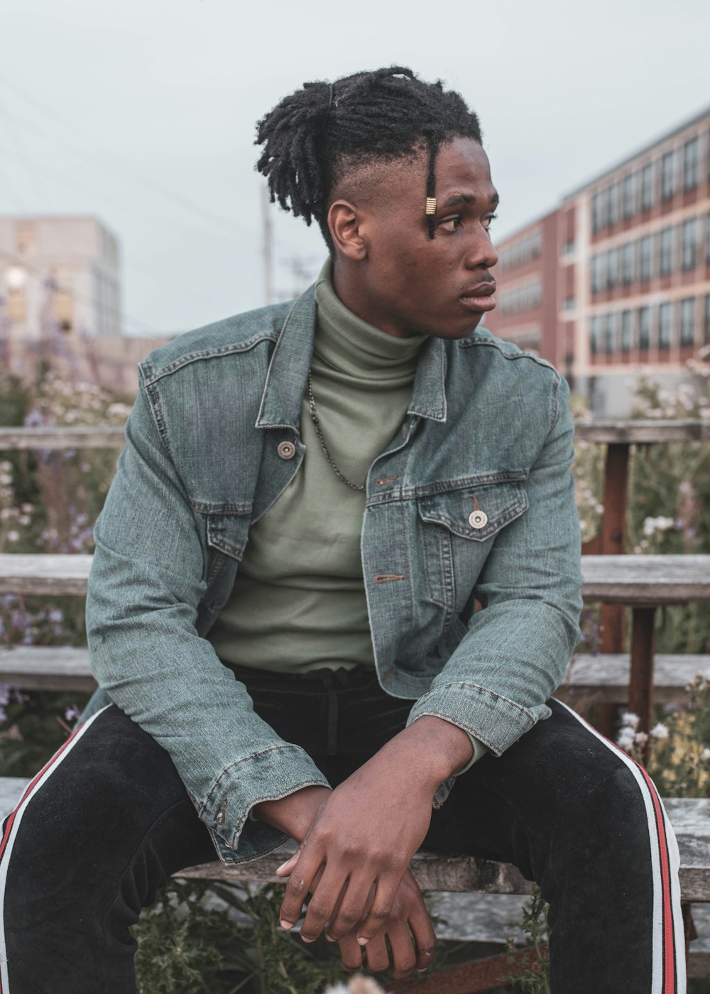 man in green button up long sleeve shirt sitting on brown wooden bench during daytime